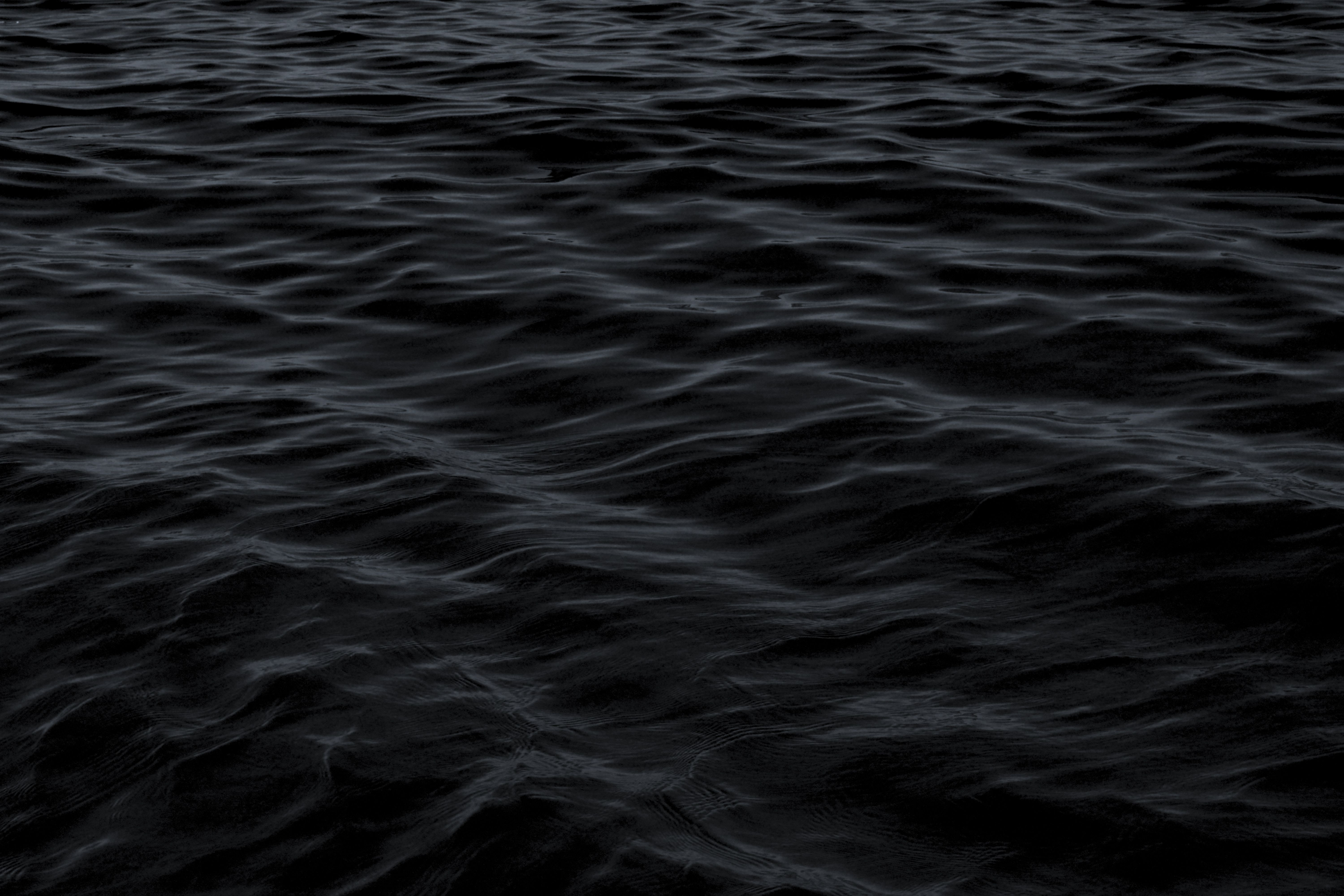 Dark, rippling water surface creates a moody and mysterious atmosphere.
