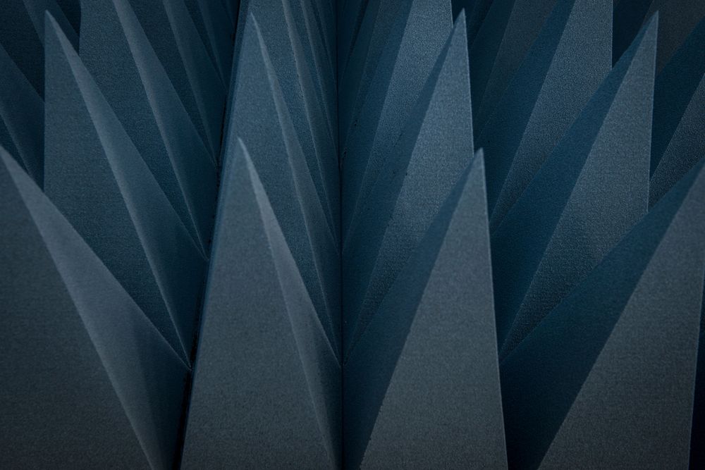 Dark blue triangular foam cones used for sound absorption create a textured wall.