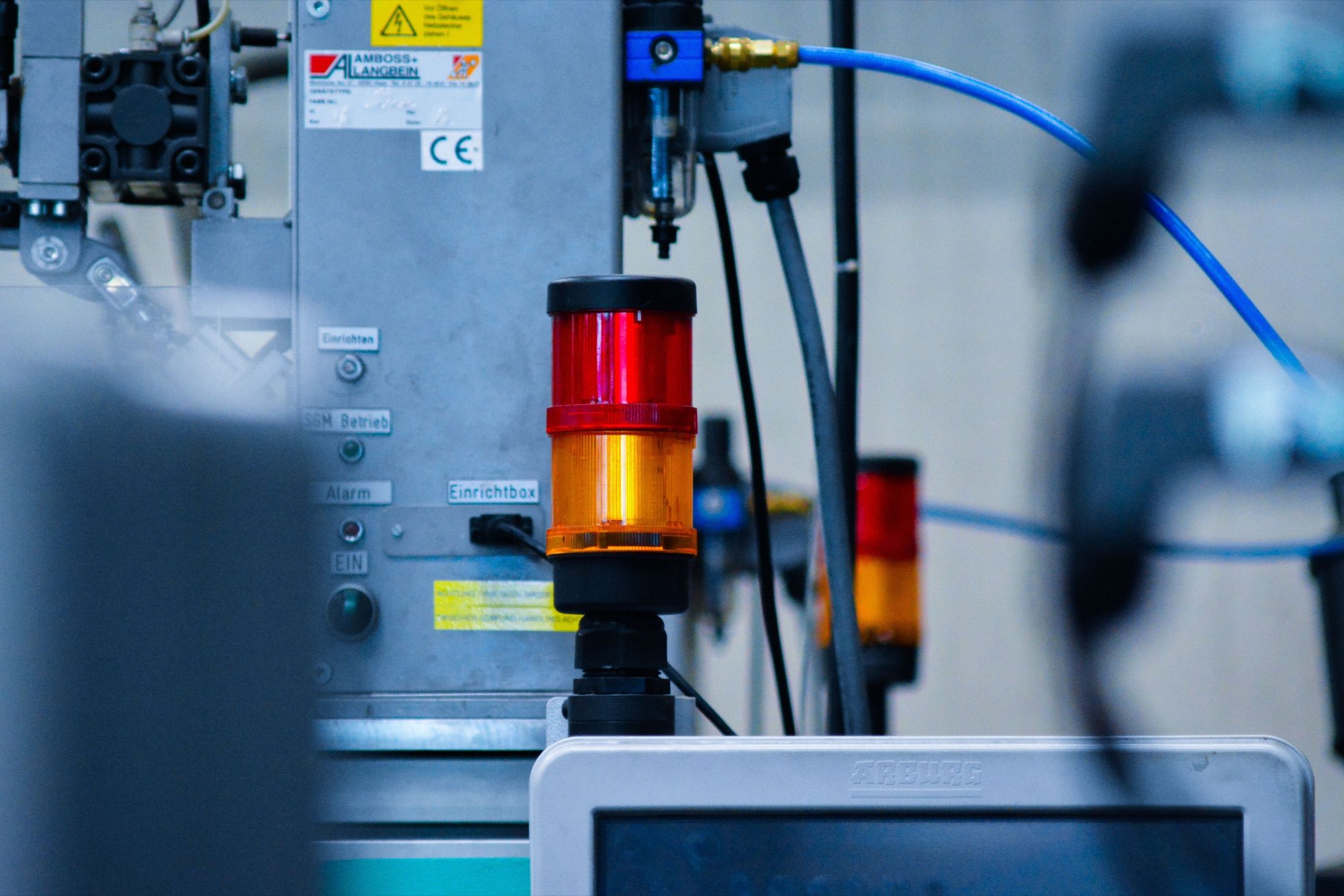 Close-up of industrial plant equipment, with indicator lights, pipework, and sensors.
